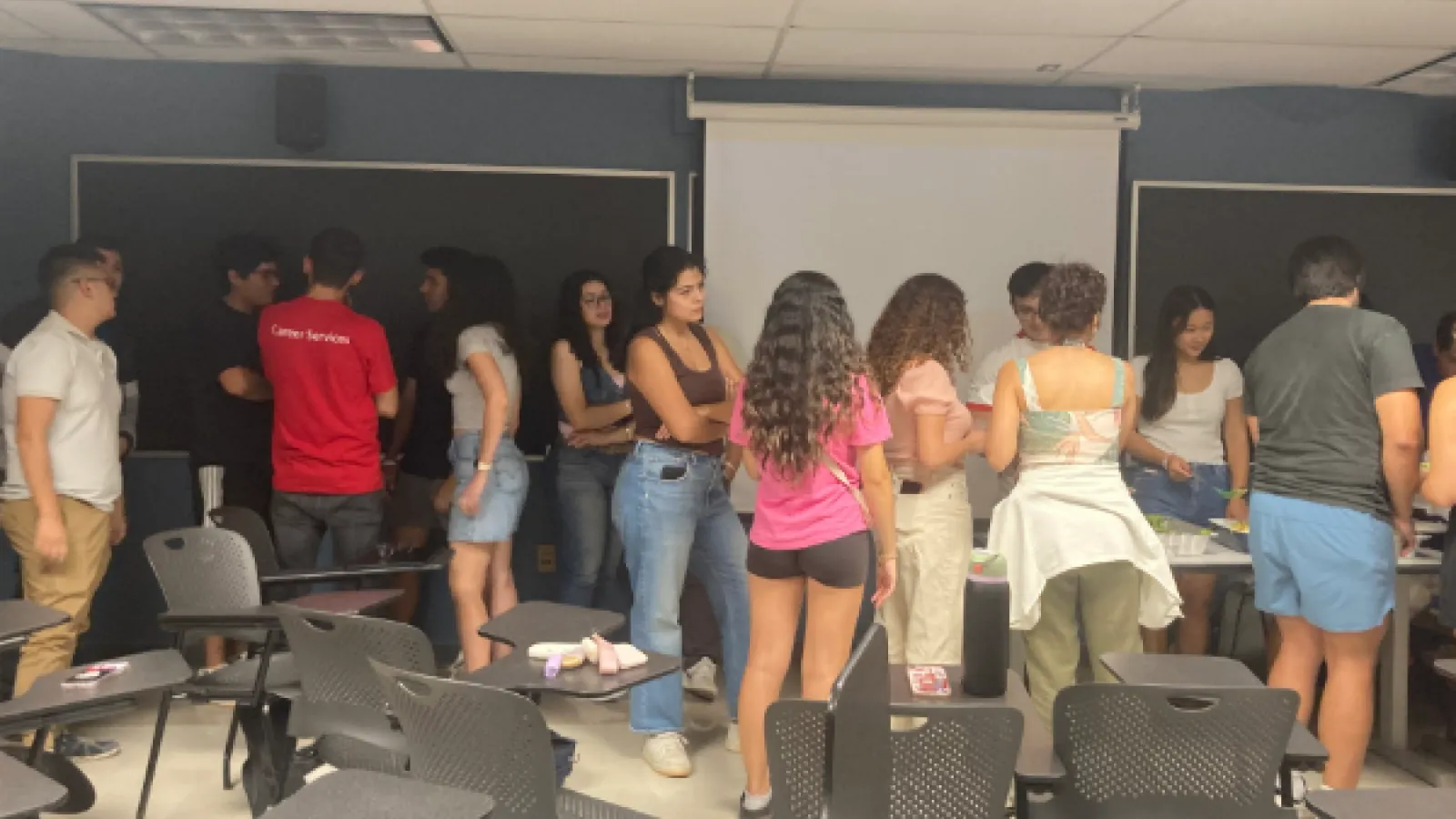 Students in classroom lining up for food.