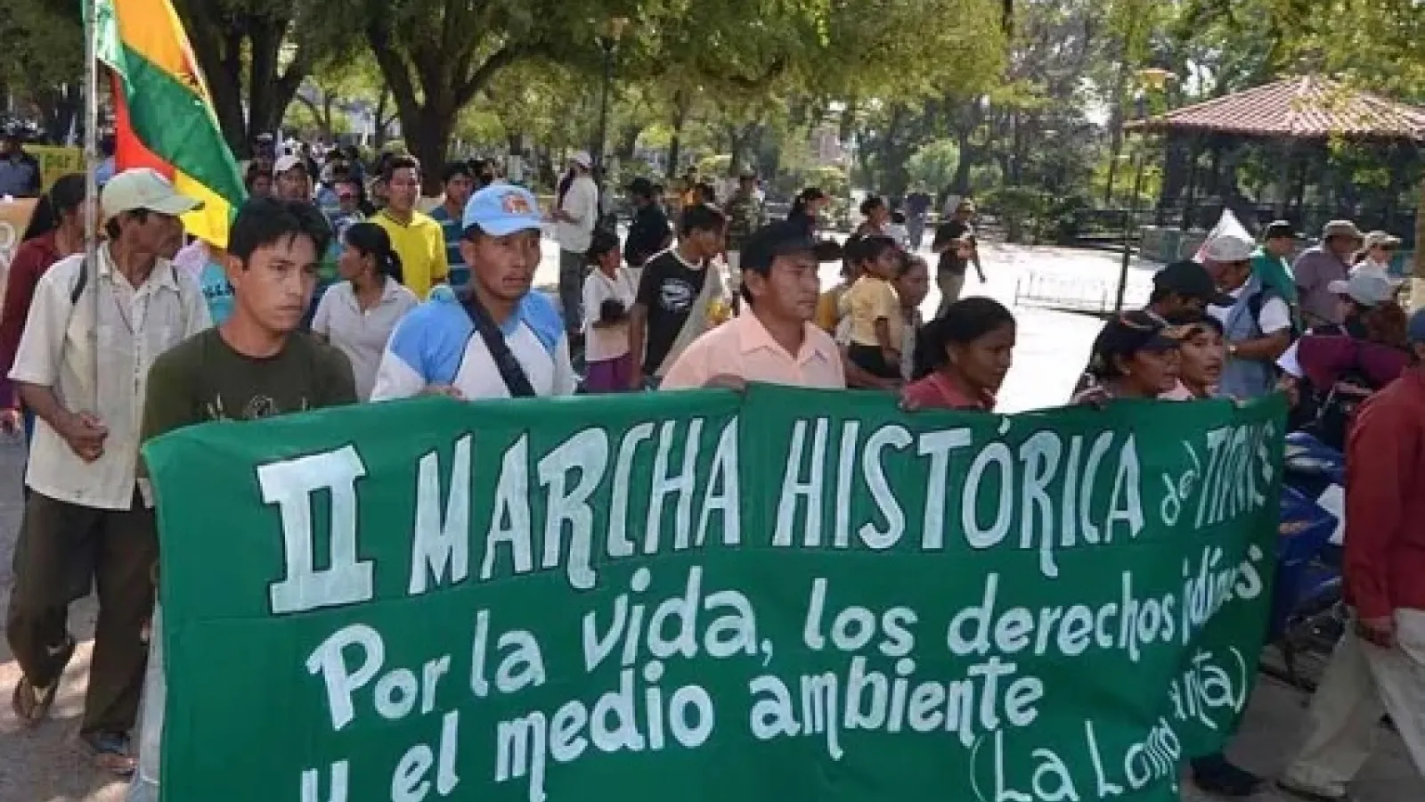 indigenous Bolivians protesting, holding green sign