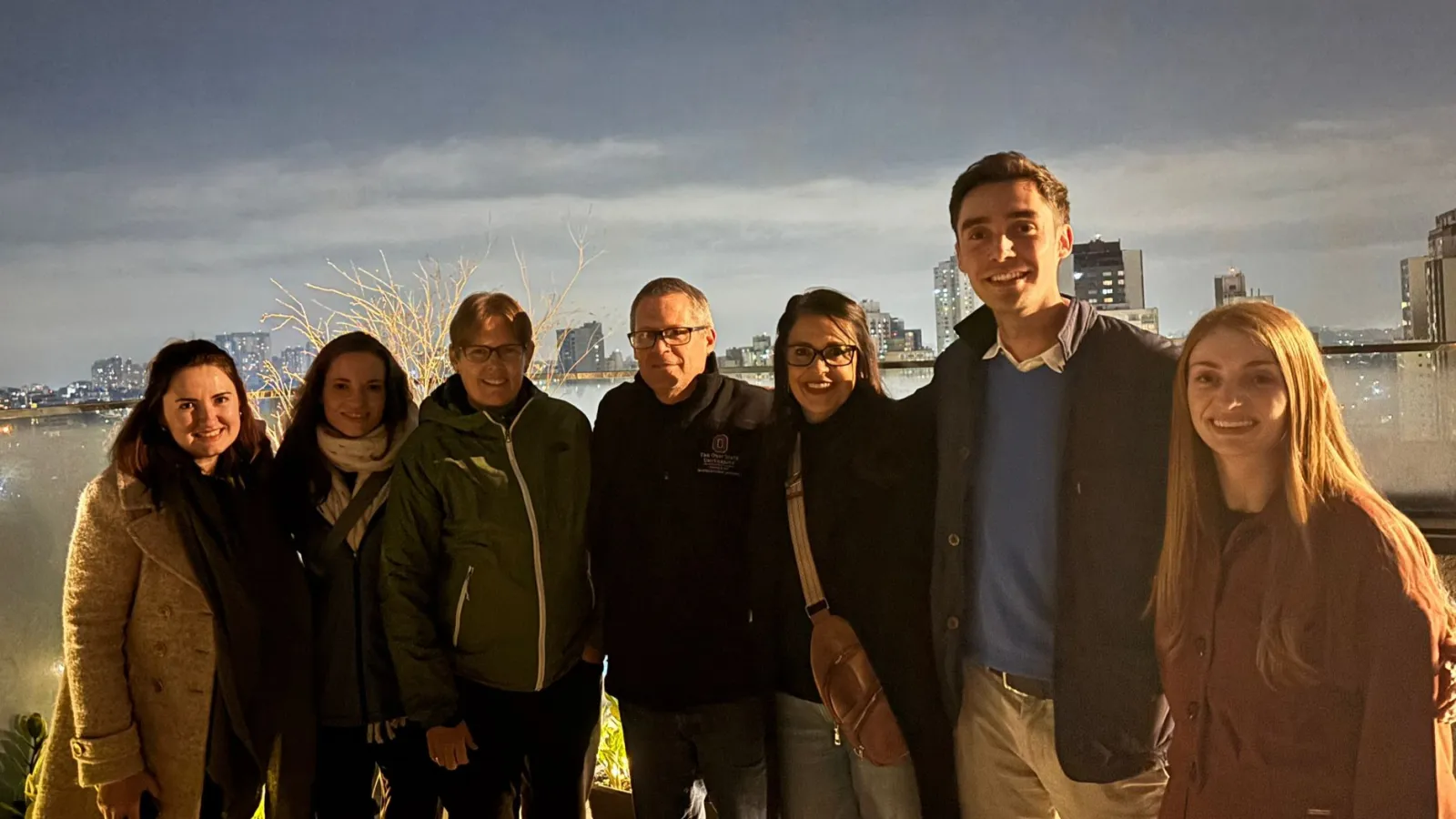 IPAST participants on a rooftop location in Curitiba with night skyline