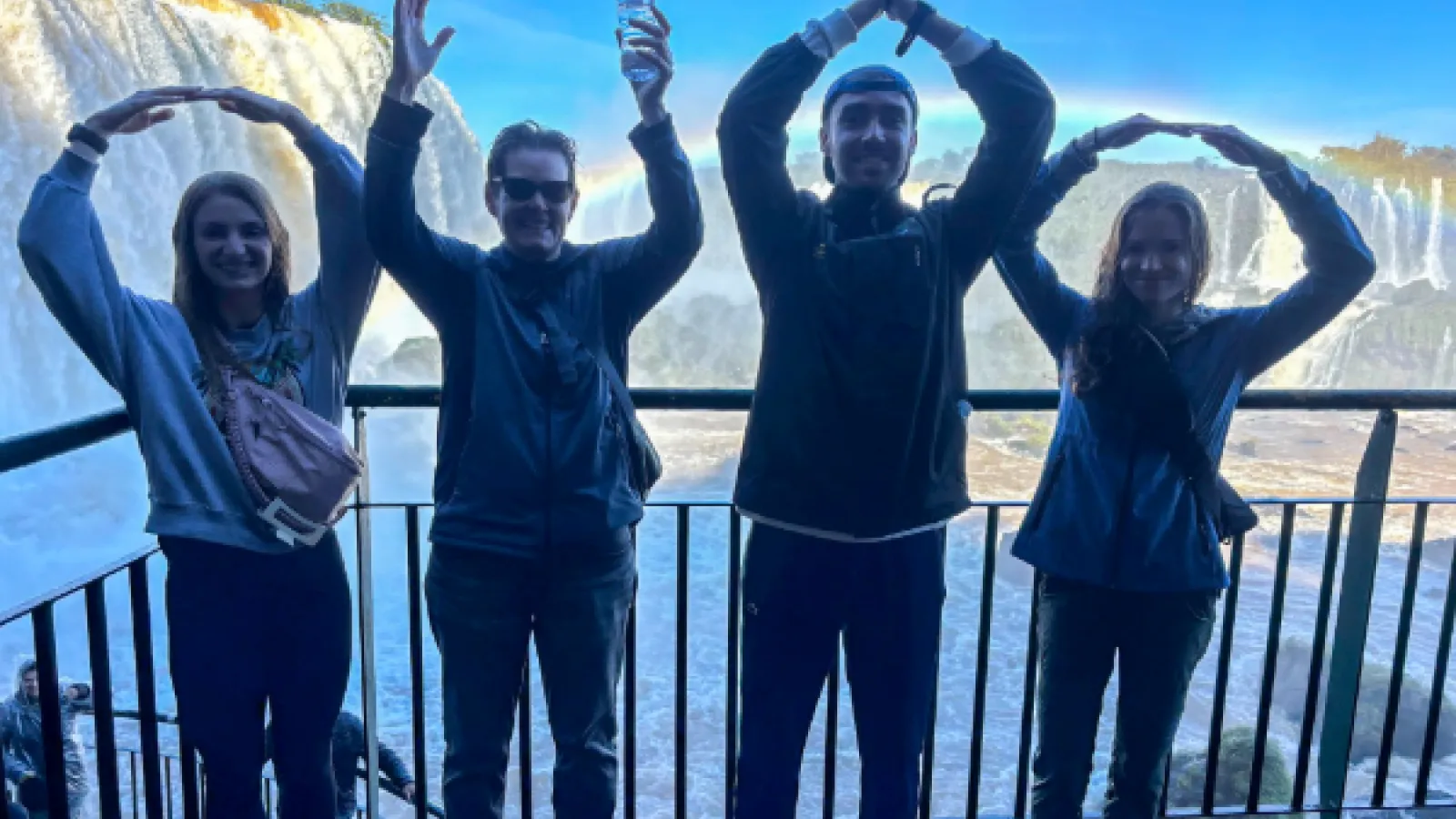 People standing in front of Iguazu Falls, spelling "OHIO" with their arms
