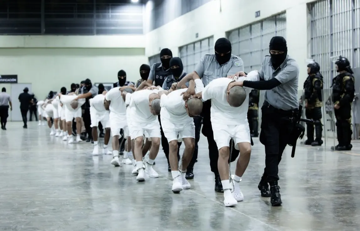 guards escorting inmates in white